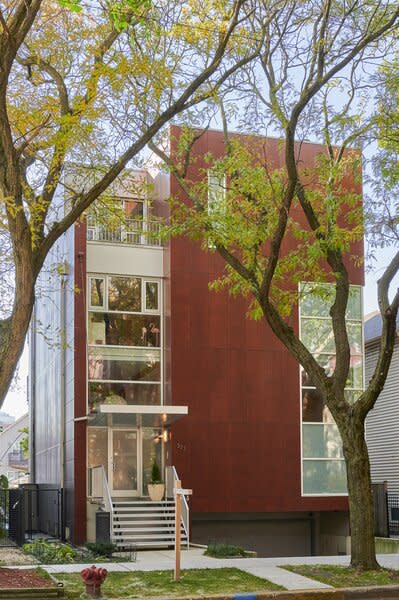 The home's contemporary wood-and-steel facade is punctuated with architectural glazing.