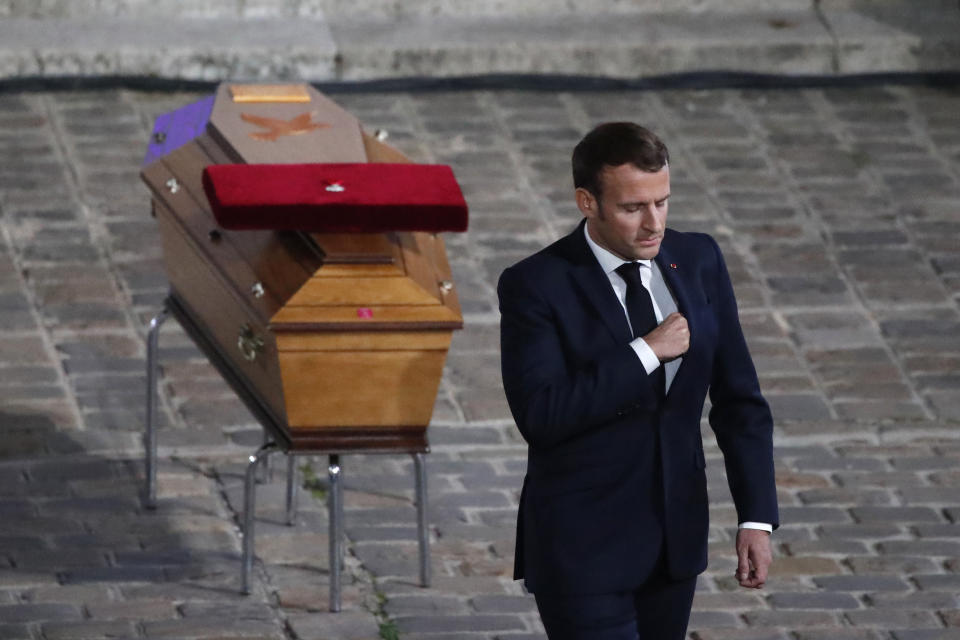 French President Emmanuel Macron leaves after paying his respects by the coffin of slain teacher Samuel Paty in the courtyard of the Sorbonne university during a national memorial event, Wednesday, Oct. 21, 2020 in Paris. French history teacher Samuel Paty was beheaded in Conflans-Sainte-Honorine, northwest of Paris, by a 18-year-old Moscow-born Chechen refugee, who was later shot dead by police. (AP Photo/Francois Mori, Pool)