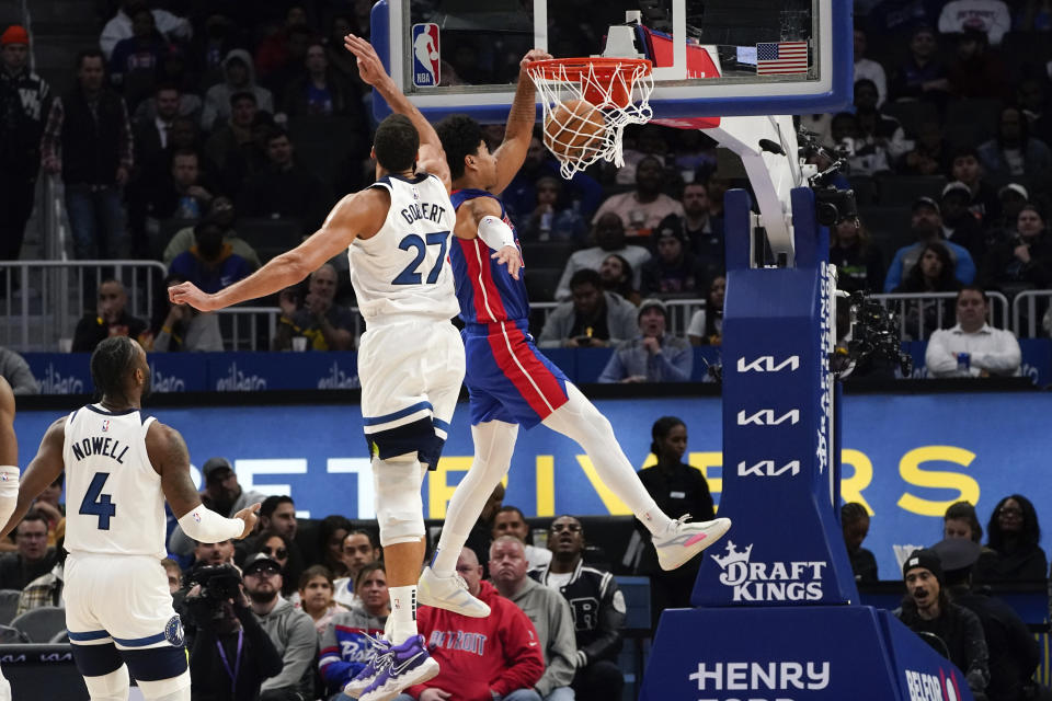 Detroit Pistons guard Killian Hayes (7) dunks on Minnesota Timberwolves center Rudy Gobert (27) in the second half of an NBA basketball game in Detroit, Wednesday, Jan. 11, 2023. (AP Photo/Paul Sancya)