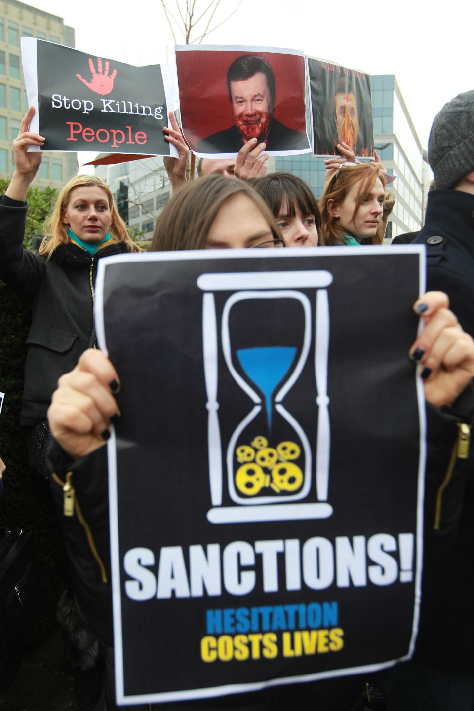 Ukrainian protesters stand outside the European Council building in Brussels, Thursday, Feb. 20, 2014. The 28-nation European Union is holding an emergency meeting on Ukraine, to consider sanctions against those behind the violence. (AP Photo/Yves Logghe)