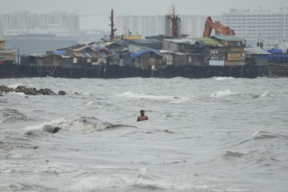 A resident swims along strong waves as Typhoon Noru approaches the seaside slum district of Tondo in Manila, Philippines, Sunday, Sept. 25, 2022. The powerful typhoon shifted and abruptly gained strength in an "explosive intensification" Sunday as it blew closer to the northeastern Philippines, prompting evacuations from high-risk villages and even the capital, which could be sideswiped by the storm, officials said. (AP Photo/Aaron Favila)
