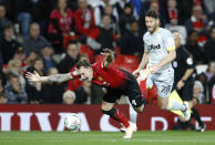 Manchester United's Phil Jones falls with Derby County's David Nugent, right, during the English League Cup, third round soccer match at Old Trafford in Manchester, England, Tuesday Sept. 25, 2018. (Martin Rickett/PA via AP)