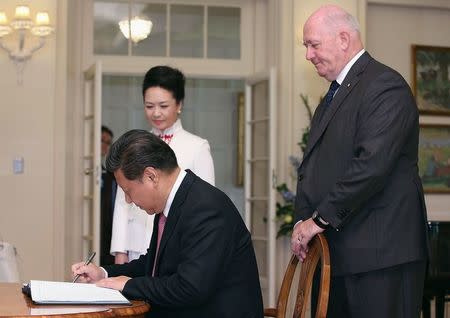 Australia's Governor-General Peter Cosgrove (R) watches as China's President Xi Jinping signs a guest book at Government House in Canberra November 17, 2014. REUTERS/Stefan Postles/Pool