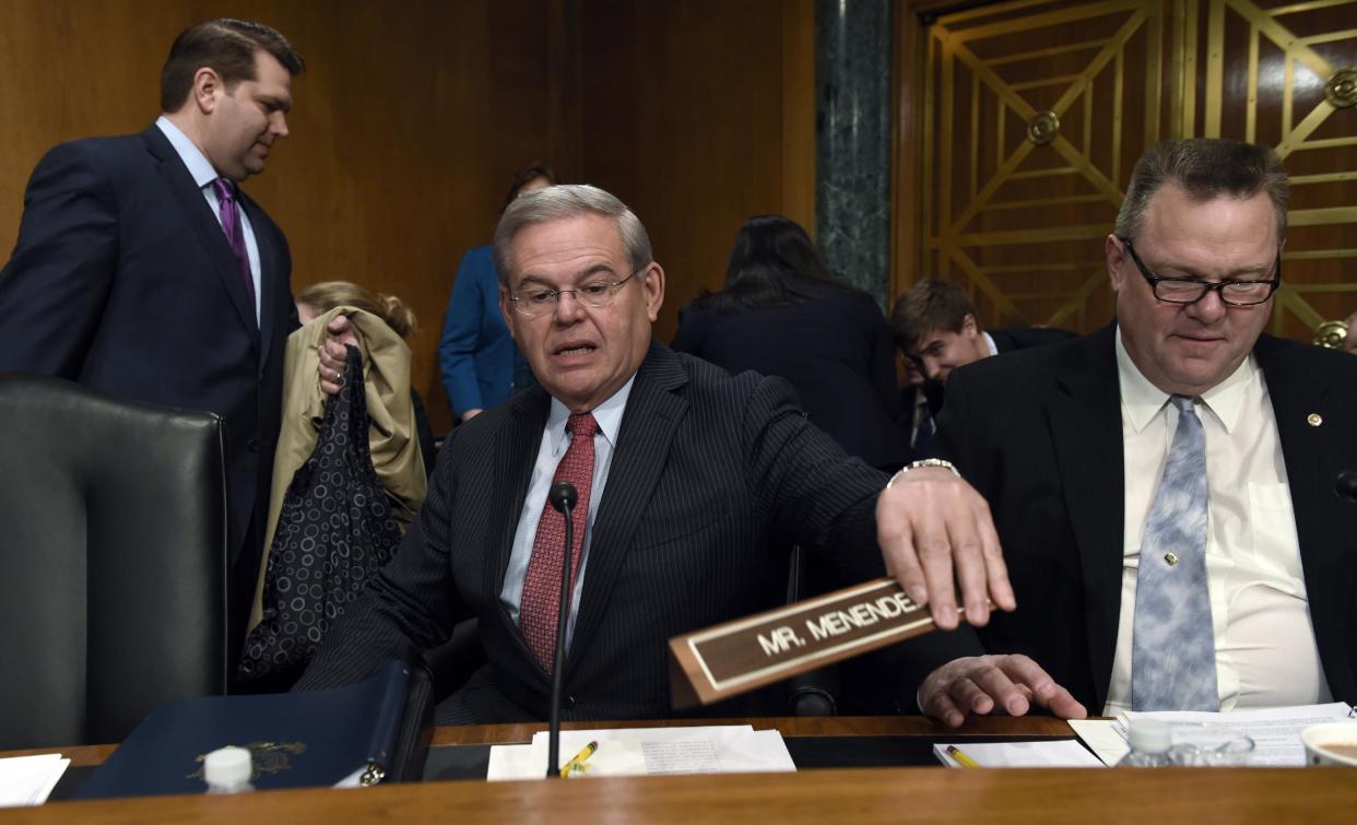 Senate Banking Committee member Sen. Robert Menendez, D-N.J., center, sitting next to Sen. Jon Tester, D-Mont., right, arrives for the committee's hearing on Iran sanctions, Tuesday, Jan. 27, 2015, on Capitol Hill in Washington. (Susan Walsh/AP Photo)