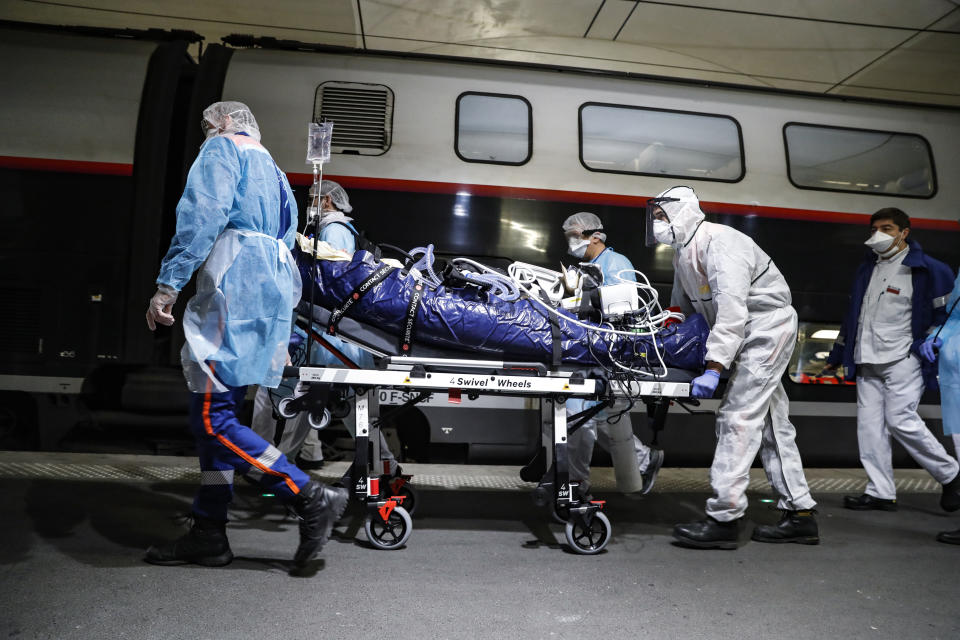 FILE - In this April 1, 2020 file photo, medical staff transfer a patient infected with the coronavirus to a train at the Gare d'Austerlitz train station in Paris. On high-speed trains fitted out like hospitals and military planes, France has moved hundreds of intensive care patients around the country in an exceptional effort to relieve congested hospitals and stay ahead of the fast-moving virus. The new coronavirus causes mild or moderate symptoms for most people, but for some, especially older adults and people with existing health problems, it can cause more severe illness or death. (Thomas Samson, Pool via AP, File)