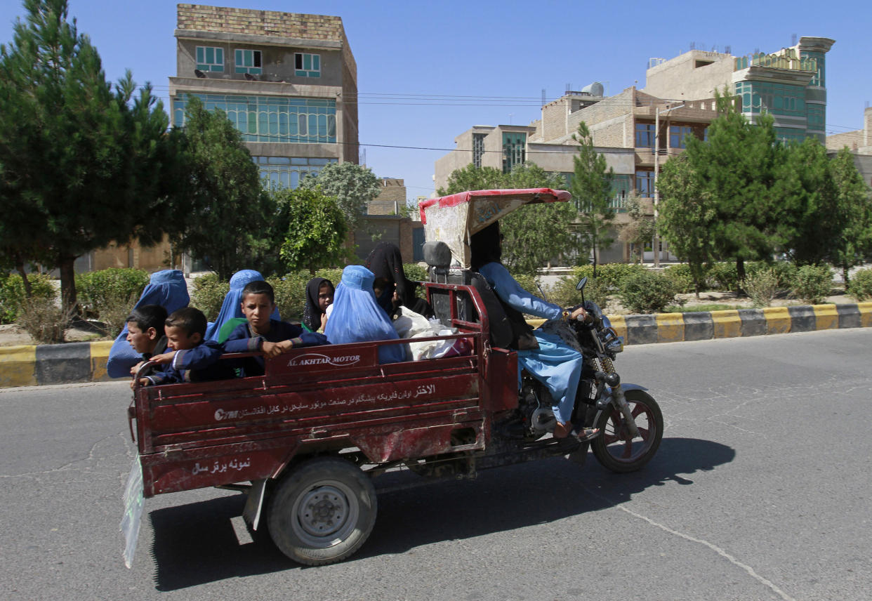 Image: Afghan women and children travel in a motorcycle cart during fighting between Taliban and Afghan security forces in Herat province (Hamed Sarfarazi / AP)