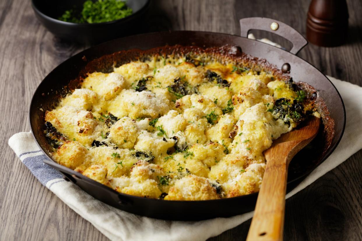 close view of creamy cauliflower kale gratin with fine chopped parsley for garnish for vegetarian diet