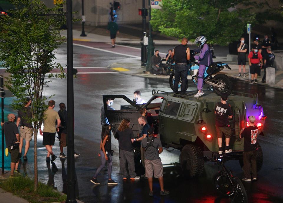 Letitia Wright, who plays the Black Panther’s sister, Princess Shuri, walked on the set of “Black Panther: Wakanda Forever” wearing a long flowing black cape covering her outfit Aug. 25, 2021. She is visible on top of the humvee in a purple outfit, for a run-through.