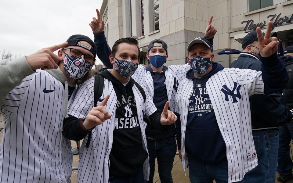 Fans pose in front of Yankee Stadium in New York on April 1, 2021 - TIMOTHY A. CLARY/AFP