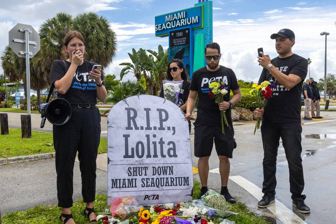 PETA organizer Amanda Brody leads a eulogy in front of volunteers, activists and media alongside a makeshift memorial during a vigil hosted by PETA for Lolita the killer whale, also known as Toki, outside Miami Seaquarium in Key Biscayne, Florida, on Saturday, August 19, 2023. Toki died from suspected renal failure on Friday after decades of captivity since the age of four.