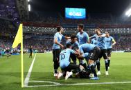 <p>Cavan is mobbed after giving Uruguay the first-half lead over Portugal in Sochi </p>