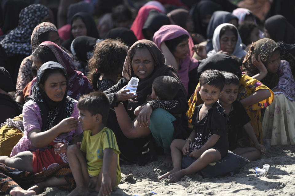 Ethnic Rohingya women and children sit on a beach after they land on a beach in Pidie, Aceh province, Indonesia, Sunday, Dec. 10, 2023. Two boats carrying hundreds of Rohingya Muslims, including women and children arrived at Indonesia's northernmost province of Aceh on Sunday morning after being adrift for weeks. (AP Photo/Riza Azhari)