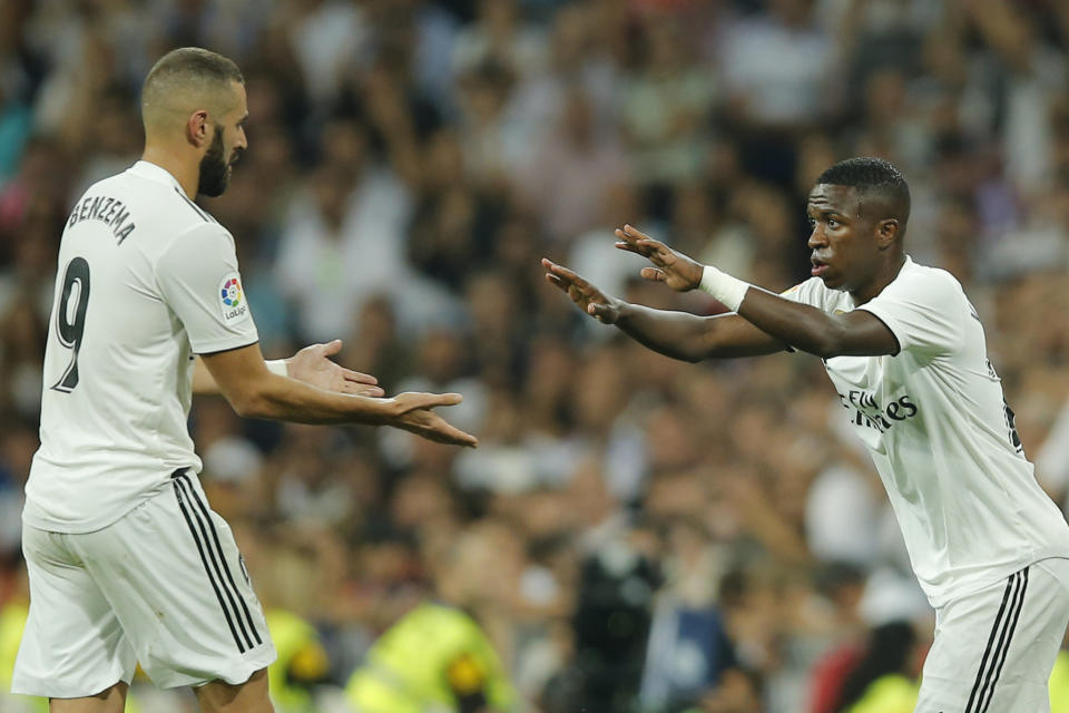 Real Madrid's Karim Benzema, left, leaves the pitch as he is substituted by Real Madrid's Vinicius Junior, right, during a Spanish La Liga soccer match between Real Madrid and Atletico Madrid at the Santiago Bernabeu stadium in Madrid, Spain, Saturday, Sept. 29, 2018. The match ended in a 0-0 draw. (AP Photo/Paul White)