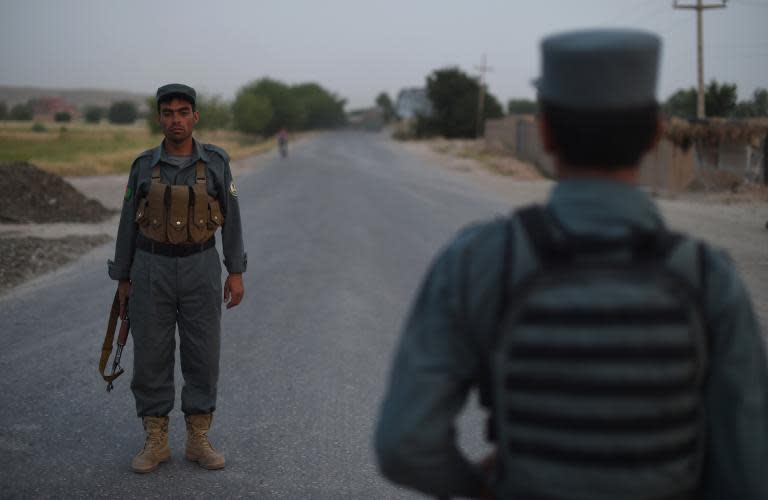 Afghan police stand guard at a checkpoint in Kunduz on May 23, 2015