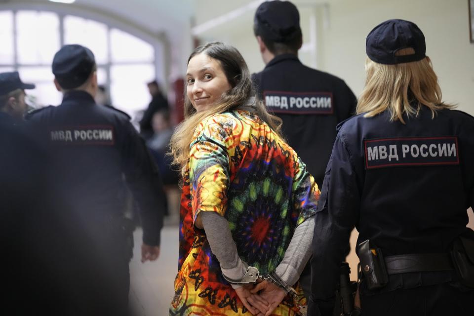 FILE - Sasha Skochilenko, a 33-year-old artist and musician, walks escorted by officers to the court room for a hearing in the Vasileostrovsky district court in St. Petersburg, Russia, on Oct. 19, 2023. Skochilenko was arrested in April 2022 on the charges of spreading false information about the army after replacing supermarket price tags with ones decrying what the Kremlin insists on calling a "special military operation" in Ukraine. The prosecution on Wednesday demanded an eight-year prison sentence for her. (AP Photo/Dmitri Lovetsky, File)
