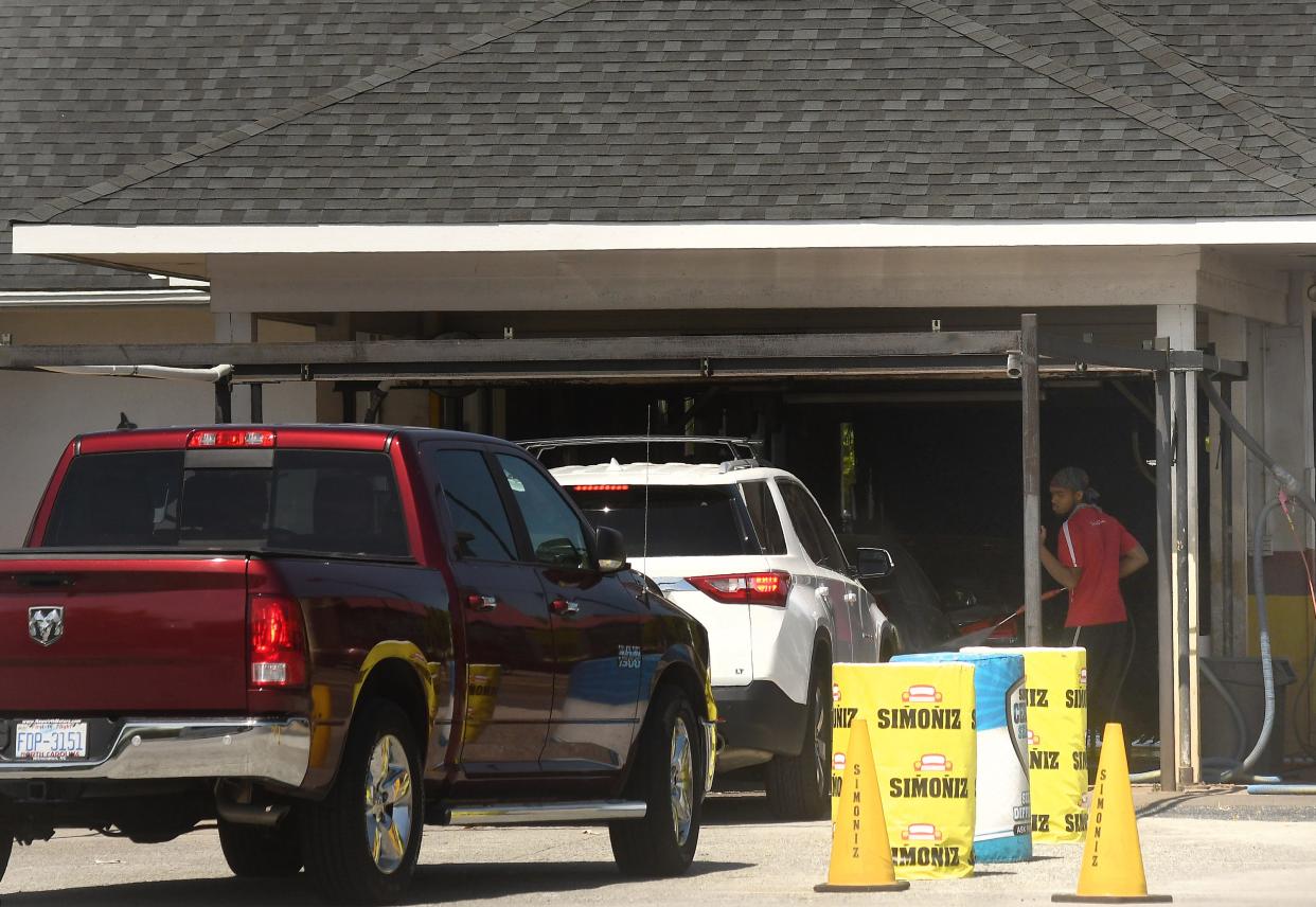 Crews work on cleaning cars as people wait at Cruisers Car Wash in Wilmington in April. Developers are looking to bring more car washes to the area.