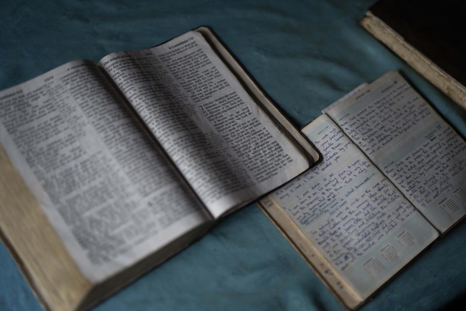 A bible is open during church service attended by Roseline Ujah in Umuida, Nigeria, Sunday, Feb. 13, 2022. Ujah's husband Godwin fell severely ill with a fever and cough. Everyone assumed at first that the palm wine tapper had contracted malaria, but then he failed to improve on medications for that disease. Doctors at a local hospital diagnosed him with COVID-19, though there were no tests available locally to confirm their suspicion. (AP Photo/Jerome Delay)