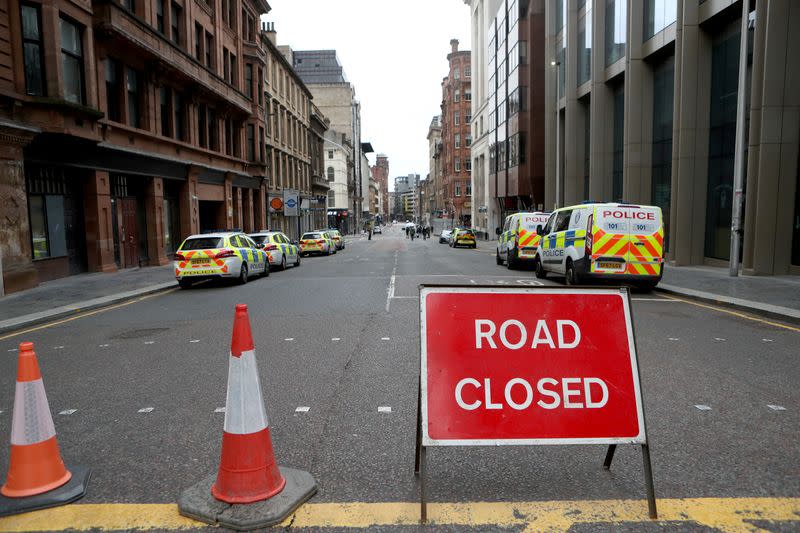 Police vehicles are seen parked near the scene of reported multiple stabbings at West George Street in Glasgow