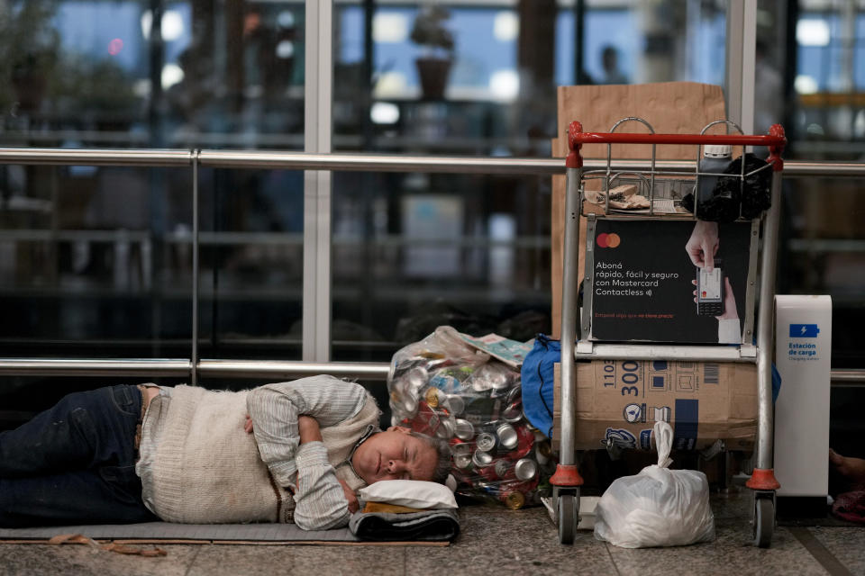 Un hombre sin vivienda duerme con sus pertenencias al lado en el aeropuerto internacional Jorge Newbery, más conocido como Aeroparque, en Buenos Aires, Argentina, el jueves 6 de abril de 2023. Una de las tasas de inflación más altas del mundo está haciendo cada vez más difícil llegar a fin de mes en Argentina, donde cuatro de cada 10 personas son pobres, según cifras oficiales de finales del año pasado. (AP Foto/Natacha Pisarenko)