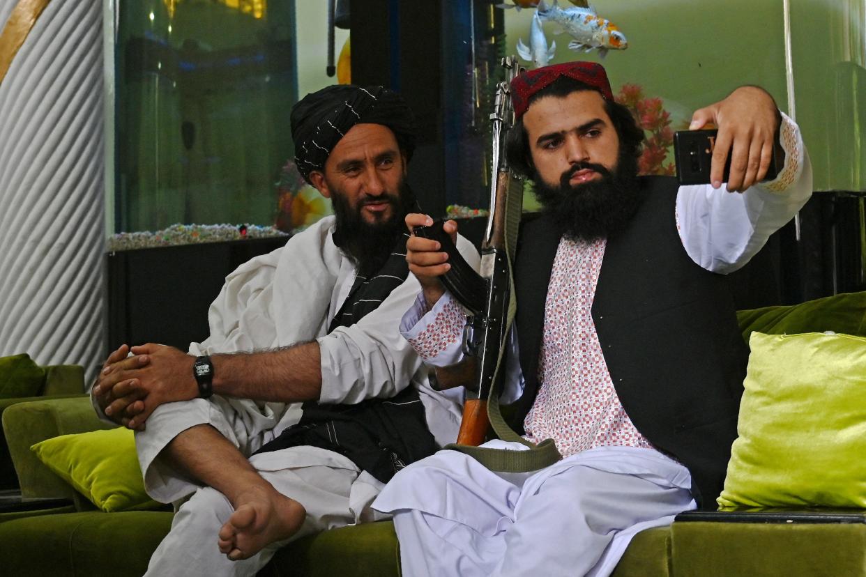 In this picture taken on September 11, 2021, Taliban fighters take their selfie with a mobile phone inside the home of the Afghan warlord Abdul Rashid Dostum in the Sherpur neighborhood of Kabul. - Taliban fighters have taken over the glitzy Kabul mansion of one of their fiercest enemies -- the warlord and fugitive ex-vice president Dostum. - TO GO WITH 'Afghanistan-Conflict-Dostum', SCENE by Emmanuel DUPARCQ (Photo by Wakil KOHSAR / AFP) / TO GO WITH 'Afghanistan-Conflict-Dostum', SCENE by Emmanuel DUPARCQ (Photo by WAKIL KOHSAR/AFP via Getty Images)