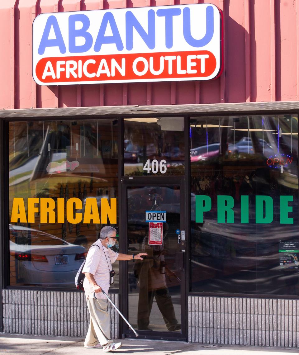 A customer waves to Dunstan Kalumba, owner of the Abantu African Consignment shop, on Jan. 20.