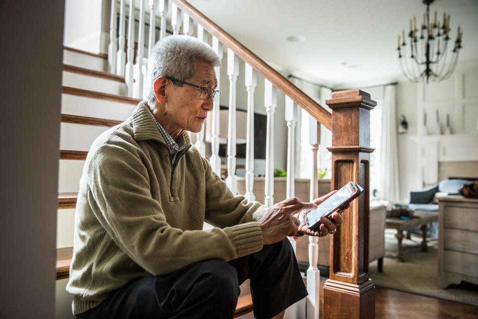 senior man using smart cell phone making phone call at home