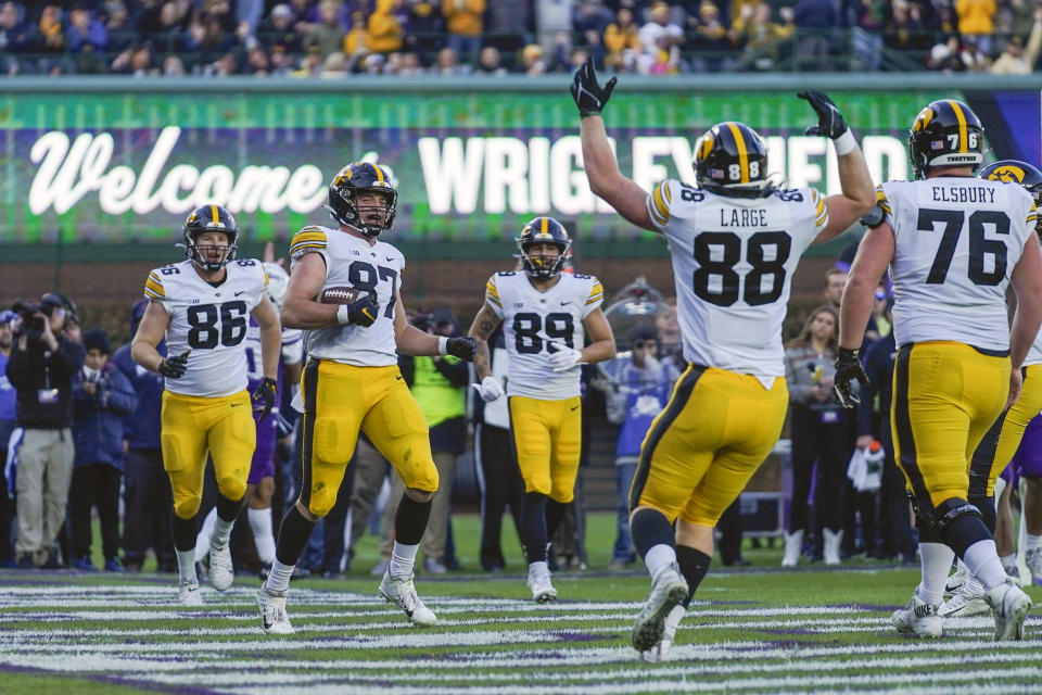 Iowa tight end Addison Ostrenga (87) celebrates with teammates after his touchdown during the second half of an NCAA college football game against Northwestern, Saturday, Nov. 4, 2023, at Wrigley Field in Chicago. (AP Photo/Erin Hooley)