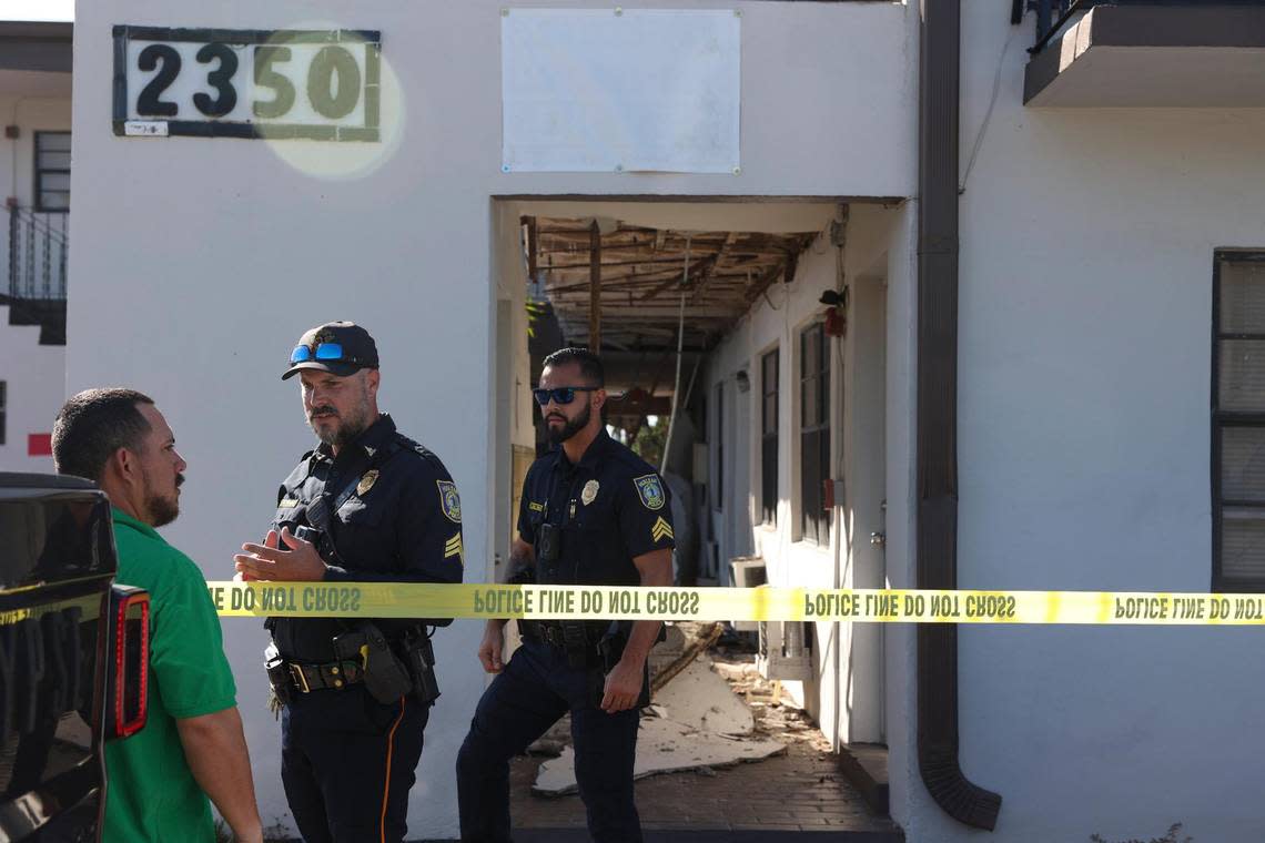 Police talk to residents after a walkway on the second floor collapsed on Monday morning, Oct. 31, 2022, and the building on Palm Avenue in Hialeah was deemed unsafe. Residents waited outside for answers all afternoon.