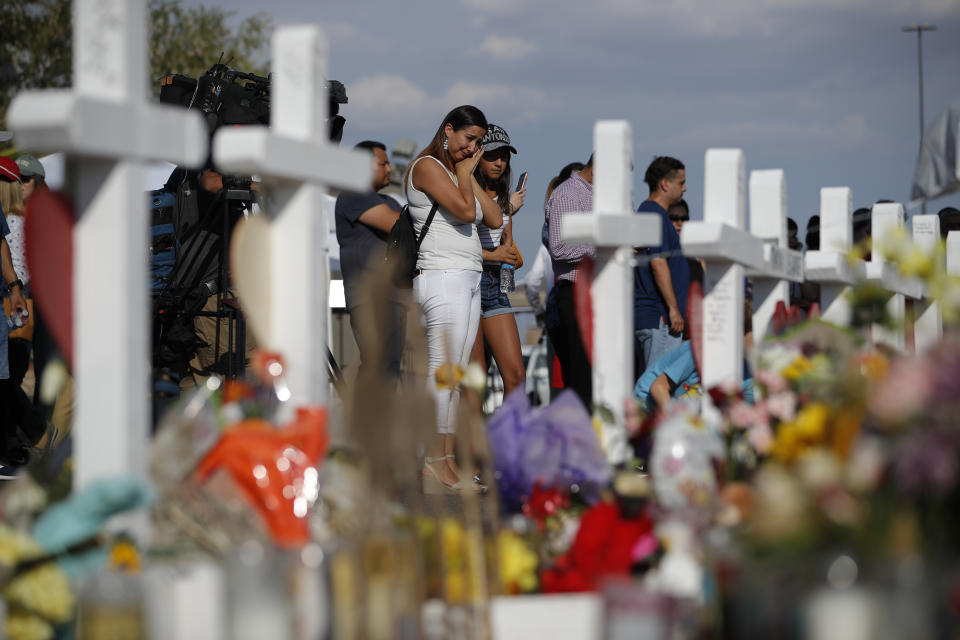 People visit a makeshift memorial, Monday, Aug. 5, 2019, at the site of a mass shooting at a shopping complex, in El Paso, Texas. (AP Photo/John Locher)