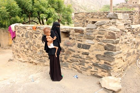 Grandmother of Malnourished Muath Ali Muhammad carries him near their home in Aslam district of the northwestern province of Hajja