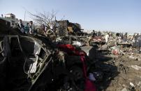 People gather at the site of an air strike at a residential area near Sanaa Airport March 26, 2015. Warplanes from Saudi Arabia and Arab allies struck Shi'ite Muslim rebels fighting to oust Yemen's president on Thursday, a gamble by the world's top oil exporter to check Iranian influence in its backyard without direct military backing from Washington. REUTERS/Khaled Abdullah