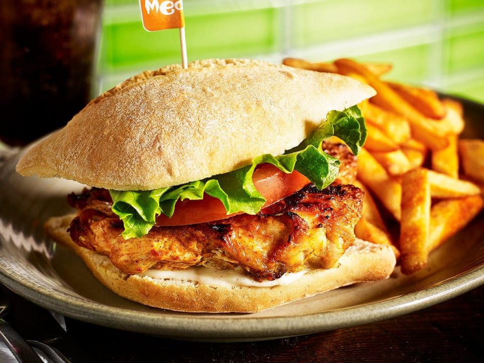 A plate of food from Nando's, with a chicken sandwich and chips.