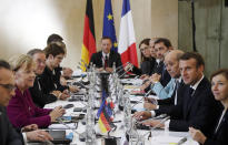 German Chancellor Angela Merkel, left, and French President Emmanuel Macron lead a joint Franco-German cabinet meeting in the government building of Toulouse, southwestern France, Wednesday, Oct.16, 2019. President Emmanuel Macron and Chancellor Angela Merkel sought Wednesday to demonstrate the solidity of the French-German relationship at a meeting in southern France, one day before a key EU summit that may approve a divorce deal with Britain.(Guillaume Horcajuelo/Pool Photo via AP)