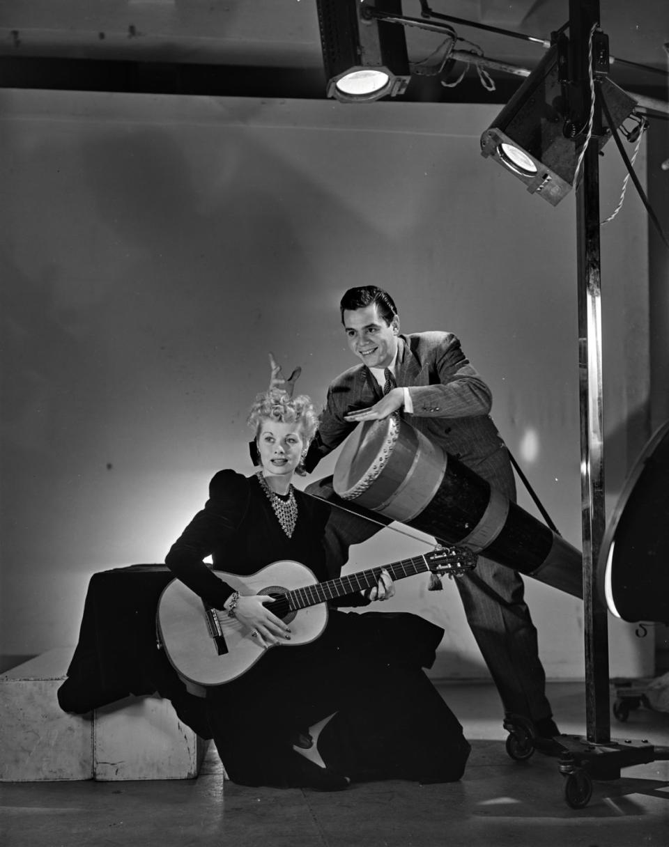 <p>Lucille and husband Desi Arnaz pose with instruments on the set of a magazine photoshoot. The couple eloped to Greenwich, Connecticut in 1940 shortly after meeting on the set of <em>Too Many Girls</em>. </p>