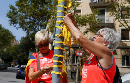 Women place yellow ribbons during Catalonia's national day 'La Diada' in Barcelona, Spain, September 11, 2018. REUTERS/Enrique Calvo