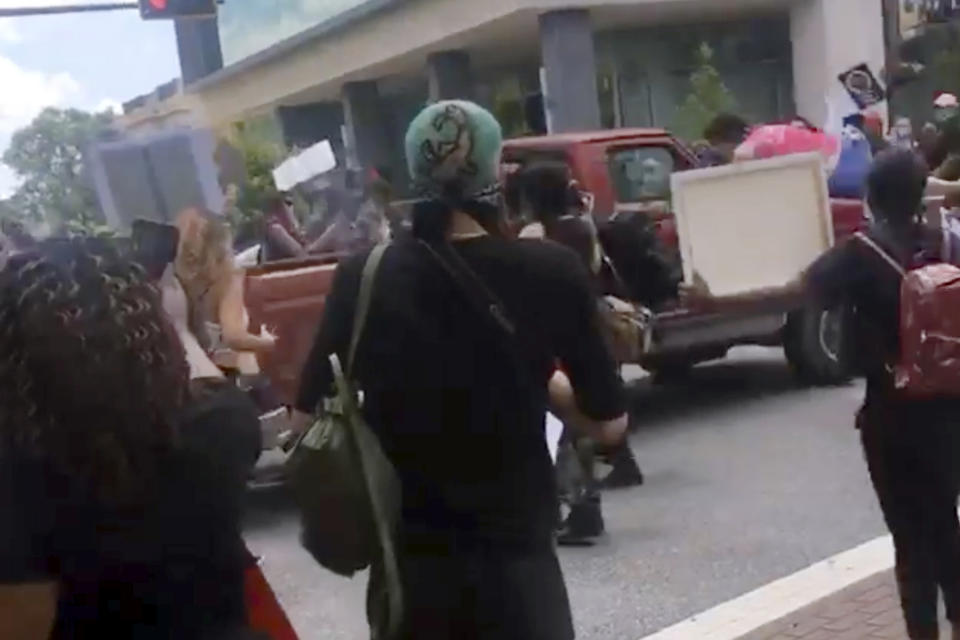 In this image taken from from video provided by @alexisnscott._, a pickup truck drives through a crowd of protesters, Saturday, May 30, 2020, in Tallahassee, Fla Tallahassee police said Saturday that the driver was in custody and that no one was seriously injured. (@alexisnscott._ via AP)