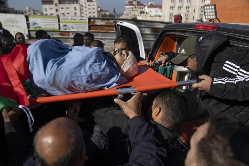 Mourners carry the body of Mohammad Dawas during his funeral in the West Bank city of Tulkarem, Friday, Jan. 19, 2024. The Israeli army withdrew early morning from the Tulkarem refugee camp after a 45 hours wide military operation in the refugee camp, the Israeli army said. Eight Palestinians were killed by the Israeli army during the Israeli army operation in the refugee camp, the Palestinian health ministry said. (AP Photo/Nasser Nasser)