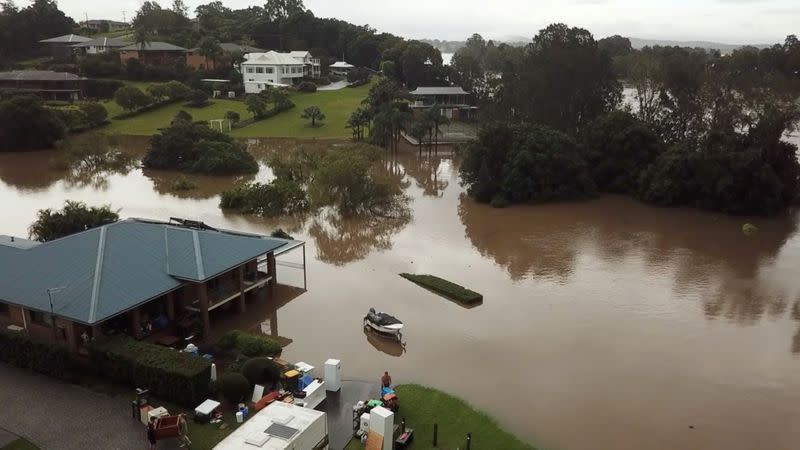 People move their belonging during floods after heavy rainfall in Tinonee