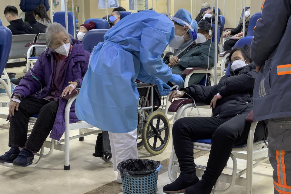 An elderly patient watches a medical worker check on a woman as they receive intravenous drips in an emergency ward in Beijing, Thursday, Jan. 19, 2023. China on Thursday accused "some Western media" of bias, smears and political manipulation in their coverage of China's abrupt ending of its strict "zero-COVID" policy, as it issued a vigorous defense of actions taken to prepare for the change of strategy. (AP Photo/Andy Wong)