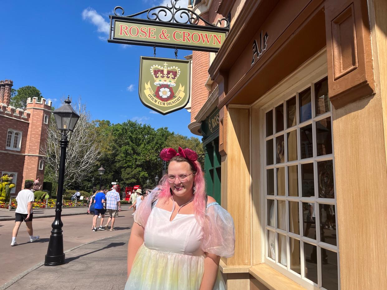casey posing in front of rose and crown restaurant in epcot at disney world
