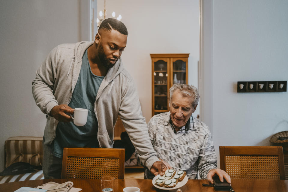 A personal care assistant helping an older man out