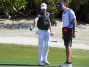 Justin Thomas, of the United States, left, studies with his caddie the line at the 5th green during the first round of the Hero World Challenge PGA Tour at the Albany Golf Club, in New Providence, Bahamas, Thursday, Dec. 2, 2021.(AP Photo/Fernando Llano)