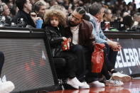 Drake sits with his son Adonis Graham as they watch the Toronto Raptors take on the Los Angeles Lakers during the first half of an NBA basketball game Wednesday, Dec. 7, 2022, in Toronto. (Chris Young/The Canadian Press via AP)