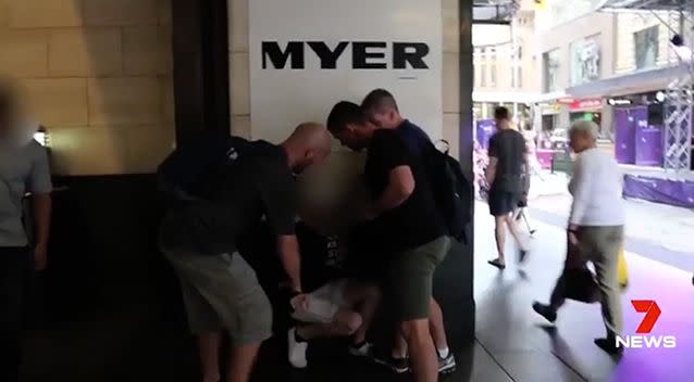 An alleged shoplifter is detained by plainclothed officers outside Myer. Photo: 7 News