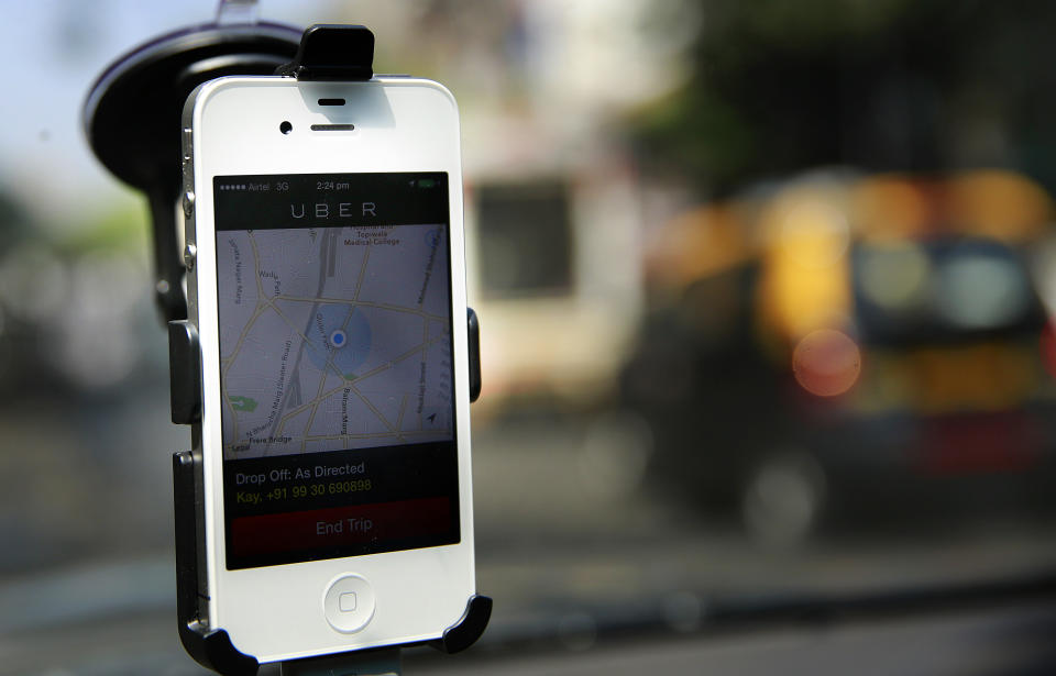 In this April 3, 2014 photo, a smartphone is mounted on the glass of an Uber car in Mumbai, India. Riding on its startup success and flush with fresh capital, taxi-hailing smartphone app Uber is making a big push into Asia. The company has in the last year started operating in 18 cities in Asia and the South Pacific including Seoul, Shanghai, Bangkok, Hong Kong and five Indian cities. (AP Photo/Rafiq Maqbool)