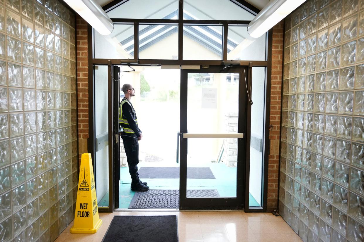 Zakkary Haze, a care coordinator with Urban Alchemy, stands at the front door at the Eighth Street Shelter. The city of Austin is pulling out of a $2 million audit of its homelessness contracts, programs and strategies with the consulting firm McKinsey & Company.