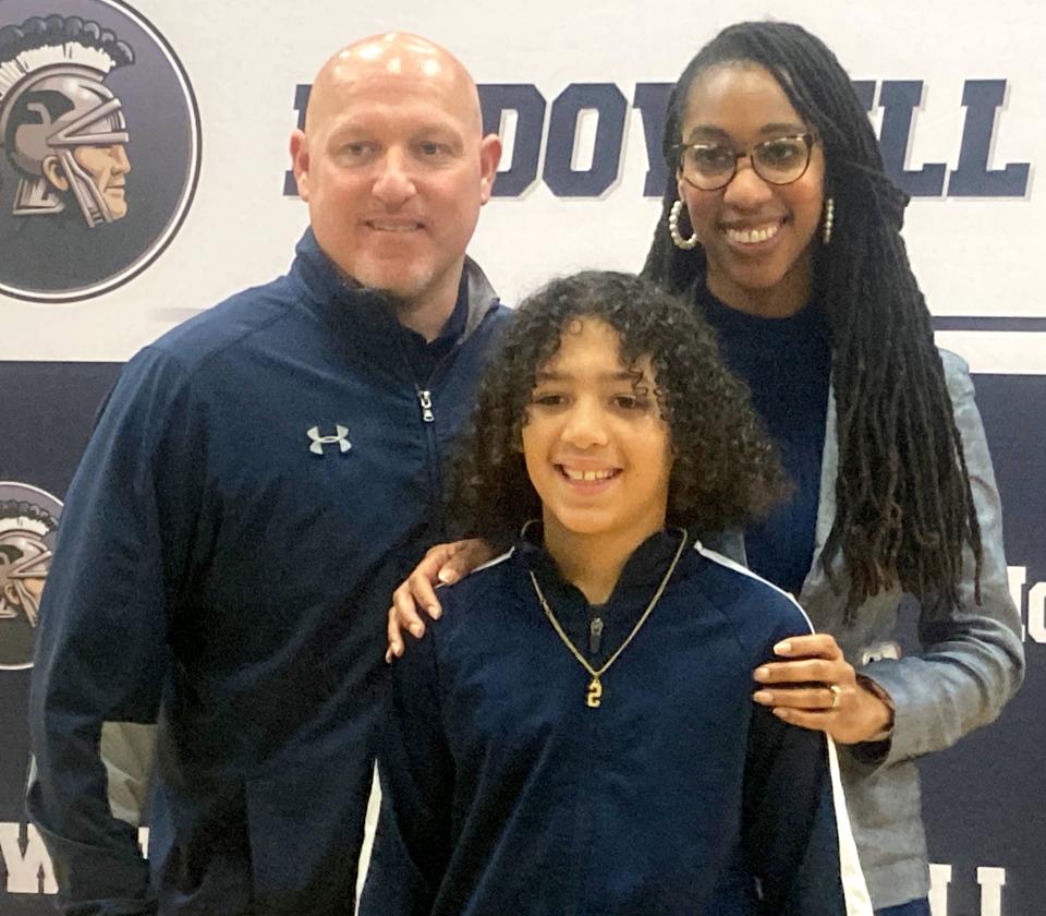 Aaron Slocum (left) poses with his wife, Chandra, and son, Micah, during McDowell High School's Friday news conference to announce him as its candidate to be the Trojans' next football coach. Slocum, a 1998 McDowell graduate, is expected to be hired during the Millcreek School District's Feb. 12 board meeting.