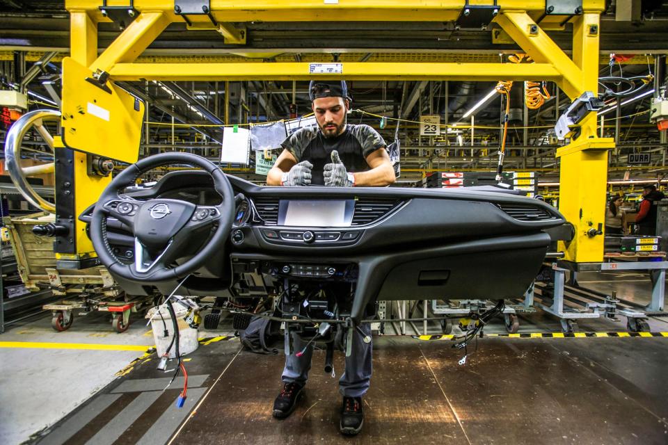 Insignia-Vormontage bei Opel in Rüsselsheim: Ein Werker bereitet das Cockpit zum Einbau vor. - Copyright: Opel