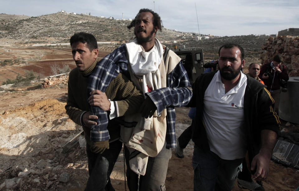 Palestinians from the village of Qusra hand over an Israeli settler (C) to the Israeli army after fellow Palestinians detained and beat a group of Israeli settlers who sparked clashes upon entering the Palestinian village near Nablus, in the Israeli occupied West Bank, on January 7, 2014, eyewitnesses and officials said. (JAAFAR ASHTIYEH/AFP/Getty Images)