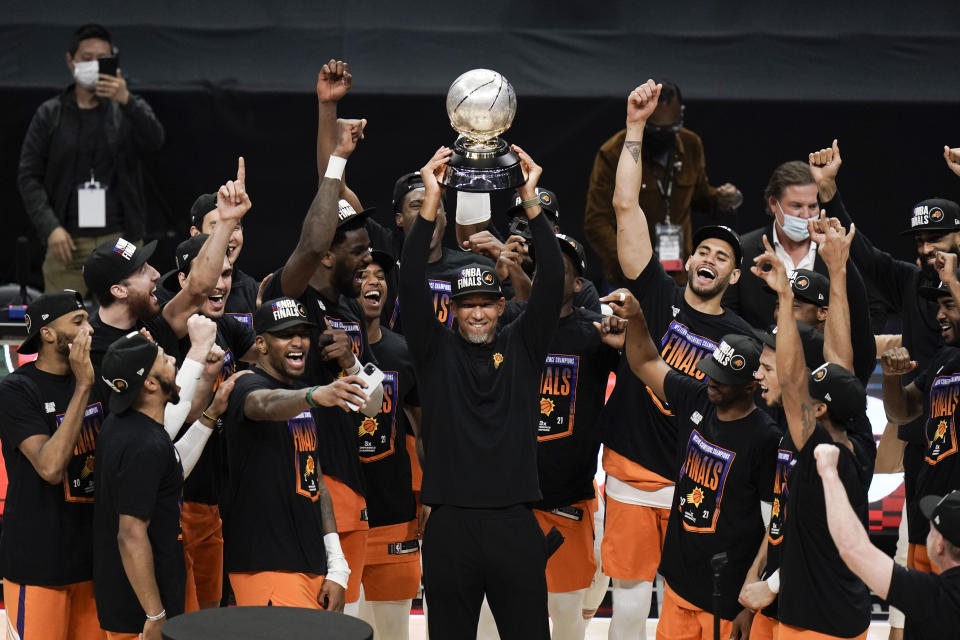 Phoenix Suns head coach Monty Williams, center, hoists the trophy as he and his players celebrate after defeating the Los Angeles Clippers in Game 6 of the NBA basketball Western Conference Finals Wednesday, June 30, 2021, in Los Angeles. (AP Photo/Jae C. Hong)